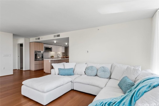 living room with dark wood finished floors and visible vents