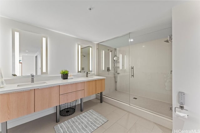 full bathroom featuring double vanity, a shower stall, a sink, and tile patterned floors