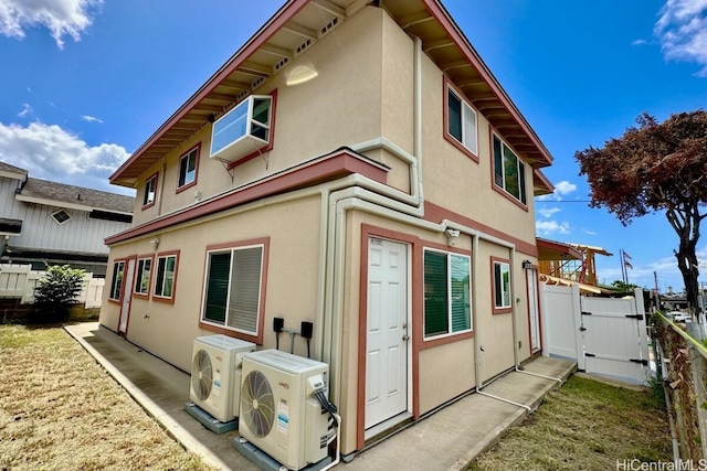 view of property exterior with ac unit, fence, and stucco siding