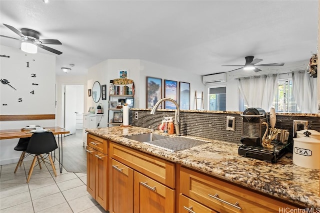 kitchen with backsplash, a wall mounted AC, light tile patterned flooring, a sink, and light stone countertops