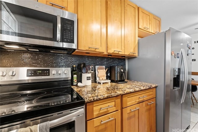 kitchen featuring appliances with stainless steel finishes, light tile patterned flooring, light stone counters, and tasteful backsplash