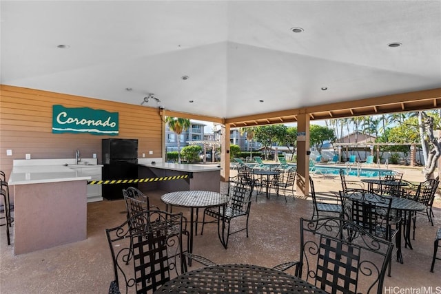 view of patio featuring a community pool and a sink