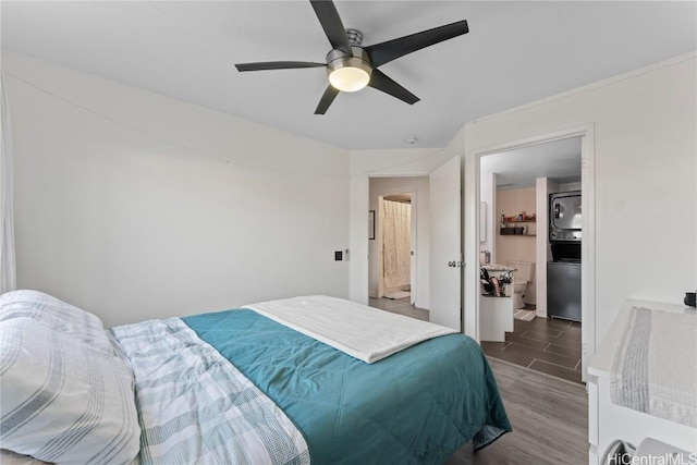 bedroom with stacked washing maching and dryer, ceiling fan, and wood finished floors