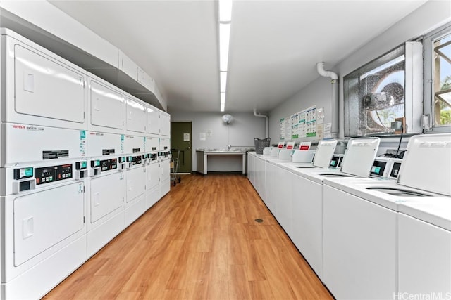 common laundry area with washer and dryer, stacked washer / dryer, and light wood-type flooring