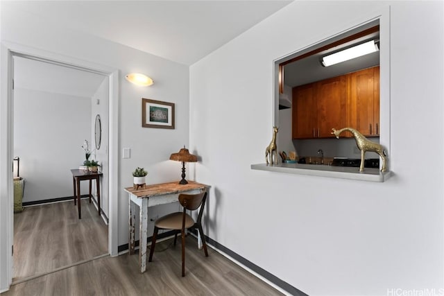 hall with baseboards and wood finished floors