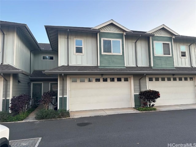 multi unit property with a shingled roof, board and batten siding, and an attached garage