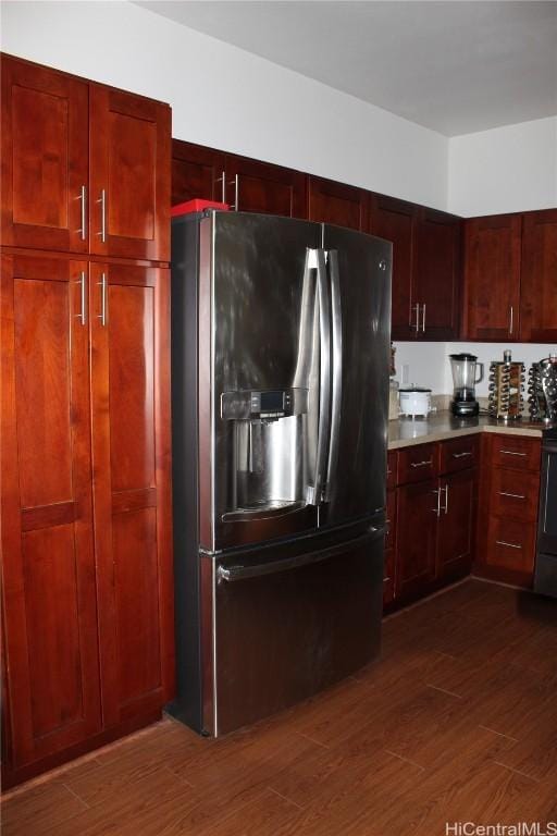 kitchen with stainless steel fridge, dark wood finished floors, and dark brown cabinets