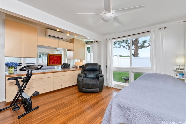 bedroom with a wall unit AC and light wood-style flooring