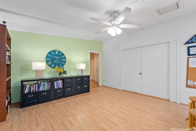 living area with ceiling fan, visible vents, and wood finished floors