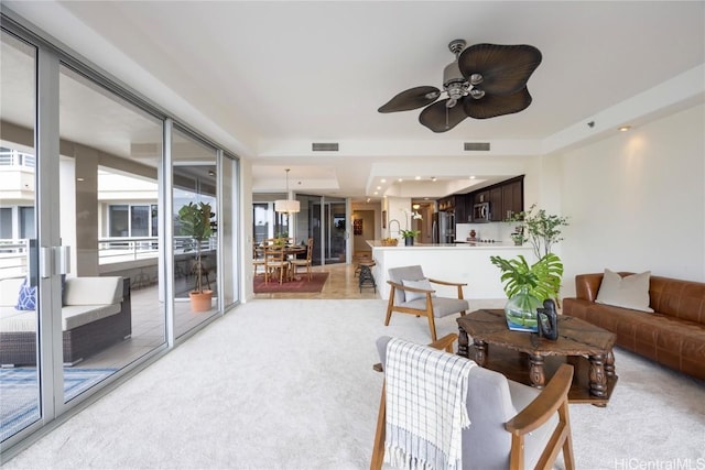 living area with light carpet, ceiling fan, and visible vents