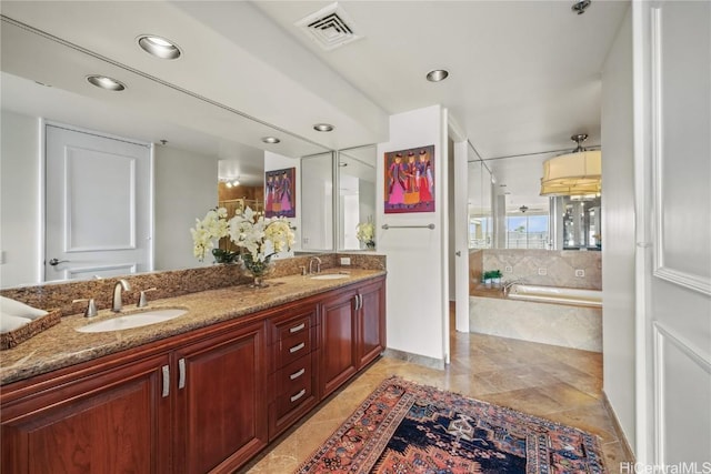 bathroom with double vanity, a garden tub, visible vents, and a sink