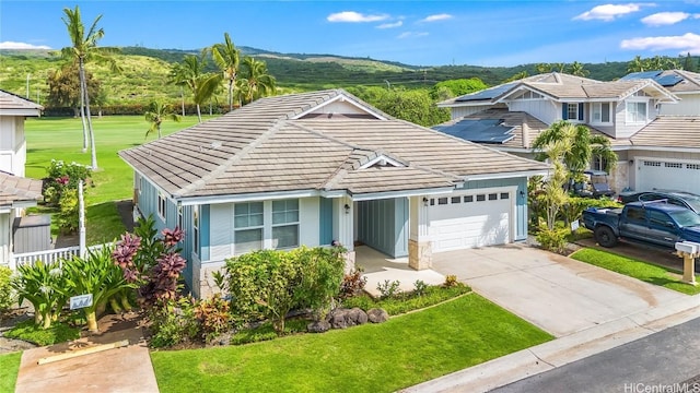 view of front of property featuring a tile roof, a front yard, fence, a garage, and driveway