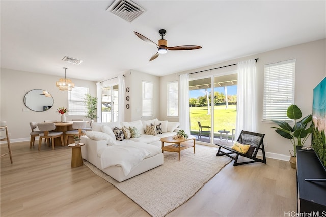 living area featuring light wood-type flooring, visible vents, and a wealth of natural light