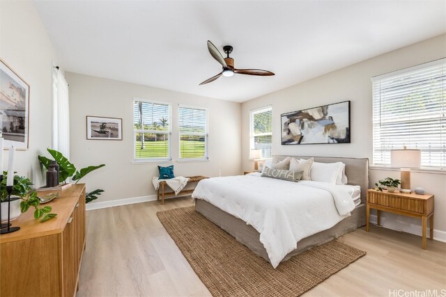 bedroom featuring ceiling fan, light wood finished floors, and baseboards