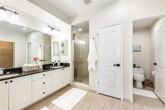 bathroom featuring tile patterned flooring, a shower stall, visible vents, and a sink