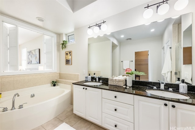 bathroom with visible vents, a sink, a bath, and tile patterned floors