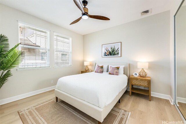 bedroom with light wood finished floors, a closet, visible vents, and baseboards