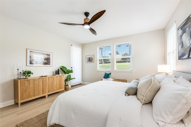 bedroom featuring a ceiling fan, light wood-style flooring, and baseboards