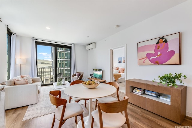 987 Queen St Unit 502, Honolulu, HI 96814 - dining room with light wood-type flooring, a wall unit AC, and a wall of windows