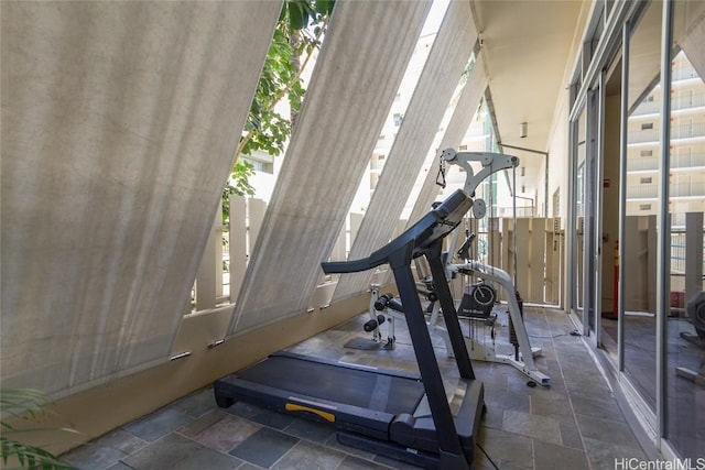 workout room featuring stone tile floors