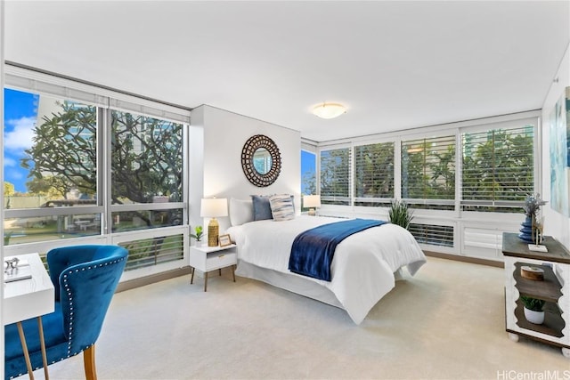 bedroom featuring light colored carpet and floor to ceiling windows