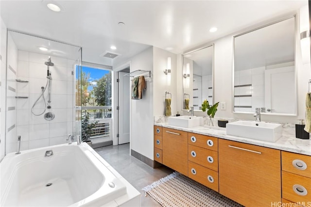 full bath with double vanity, a garden tub, a shower stall, and a sink