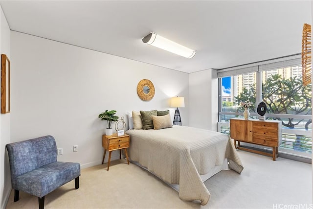 bedroom featuring light carpet, floor to ceiling windows, and baseboards