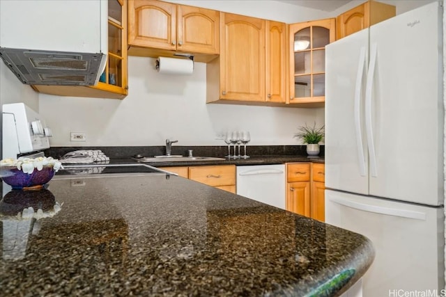 kitchen featuring dark stone counters, white appliances, a sink, and glass insert cabinets