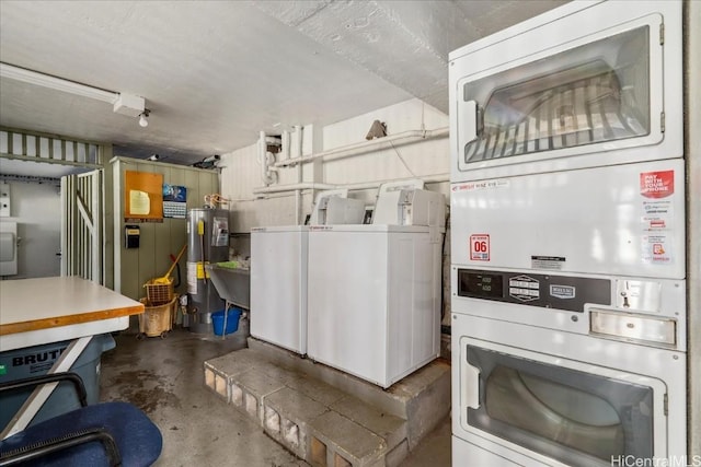 kitchen with washing machine and dryer, water heater, unfinished concrete flooring, and stacked washer / dryer