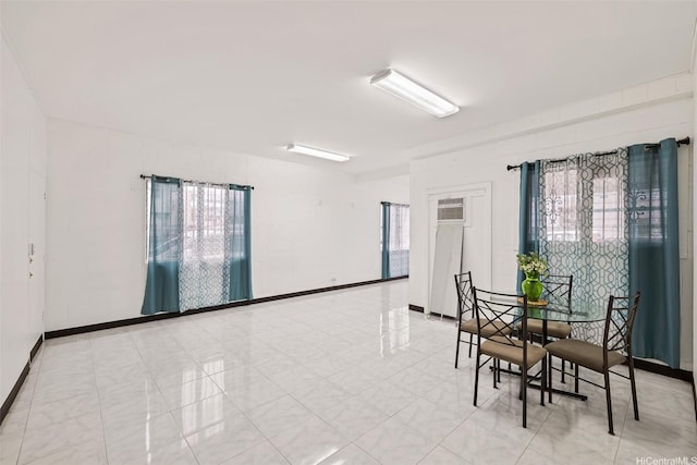 unfurnished room with a wall mounted AC and baseboards