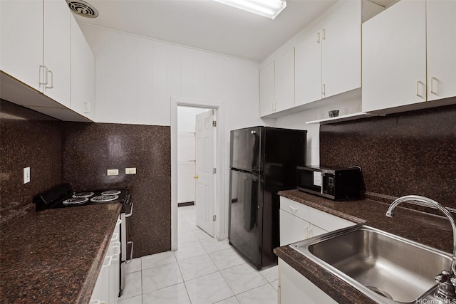 kitchen with freestanding refrigerator, white cabinetry, stainless steel microwave, a sink, and electric range oven