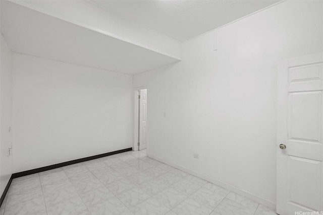 empty room with baseboards and light floors