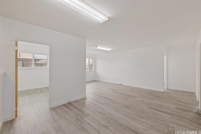 spare room with light wood-style floors and baseboards