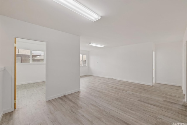 unfurnished room with baseboards and light wood finished floors