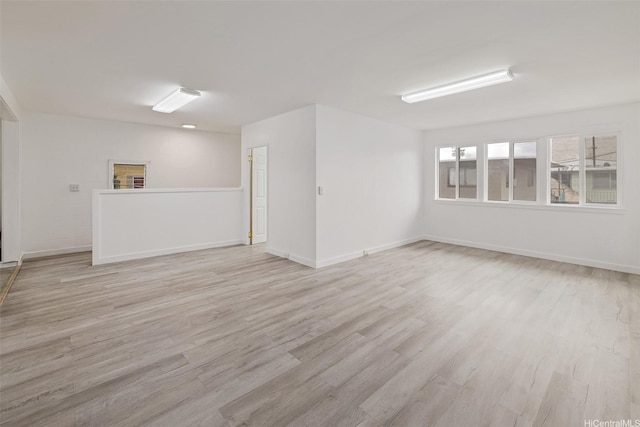spare room featuring light wood-style flooring and baseboards