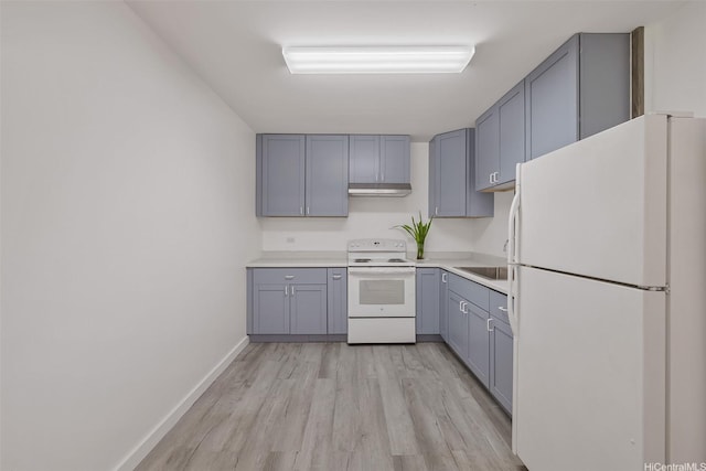 kitchen with white appliances, light wood-style flooring, light countertops, gray cabinetry, and under cabinet range hood