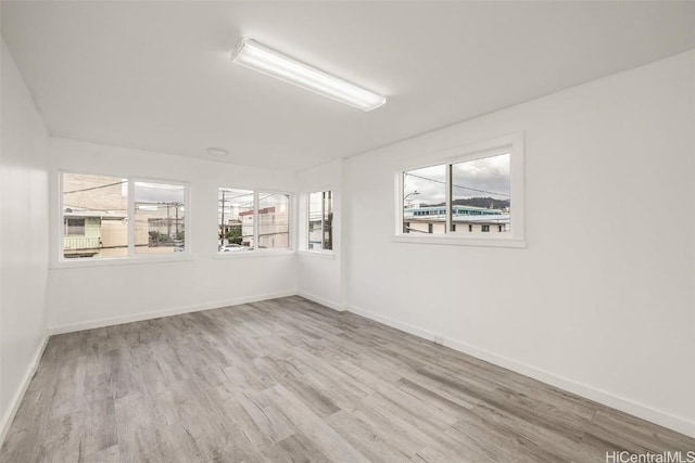 empty room with baseboards and wood finished floors