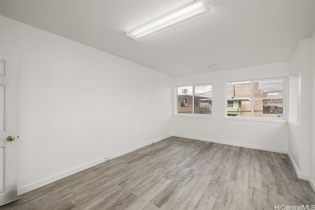 empty room with baseboards and wood finished floors