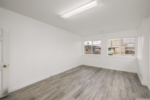 spare room featuring wood finished floors and baseboards