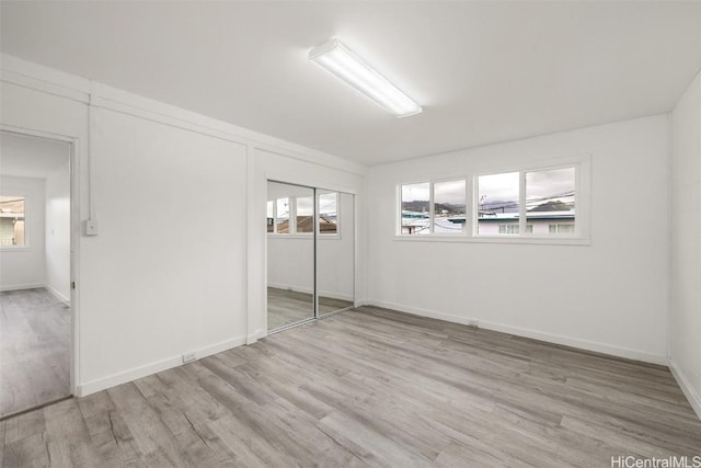 empty room with baseboards and wood finished floors