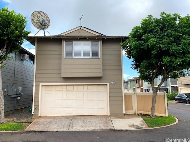 view of front facade featuring a garage, fence, concrete driveway, and an AC wall unit