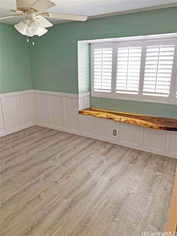 spare room featuring ceiling fan, light wood-style floors, and a healthy amount of sunlight