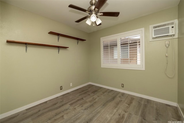 91-1016C Hoomaka St Unit 78, Ewa Beach, HI 96706 - spare room featuring an AC wall unit, wood finished floors, ceiling fan, and baseboards