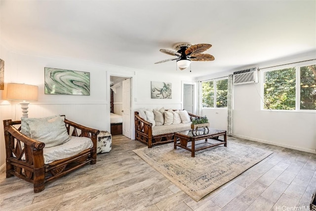 living room featuring a wall mounted air conditioner, a ceiling fan, and light wood-style floors