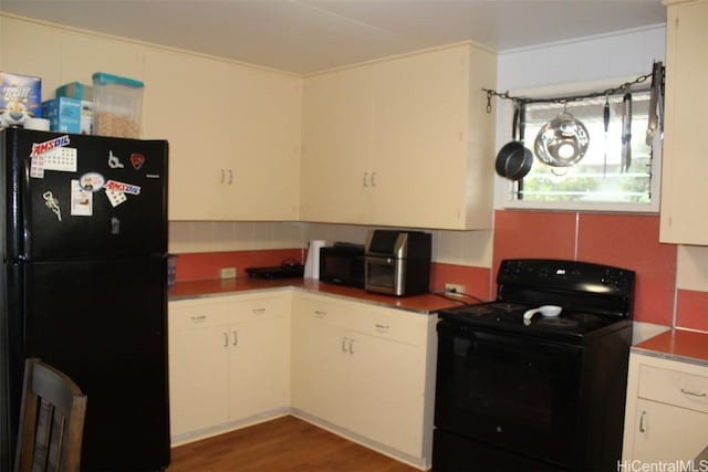 kitchen featuring black appliances, dark wood-style floors, and white cabinetry