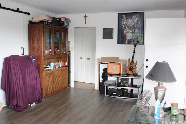 miscellaneous room with a barn door and dark wood-style flooring