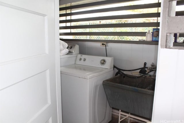 washroom featuring washer / dryer, laundry area, and a sink