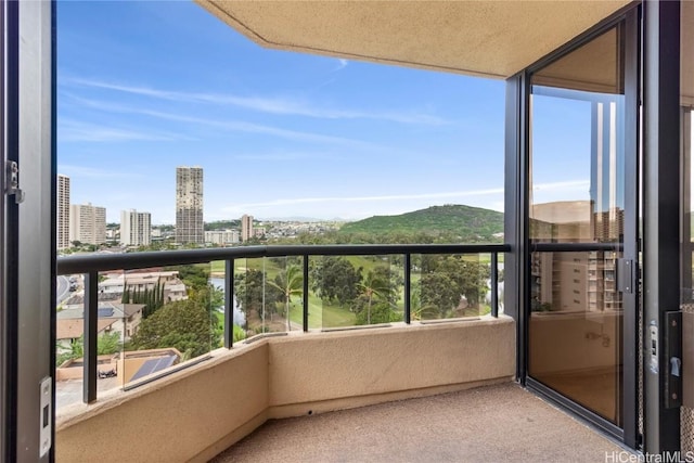 balcony with a mountain view and a city view