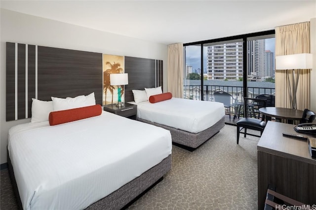 bedroom featuring a view of city, access to outside, carpet, and floor to ceiling windows