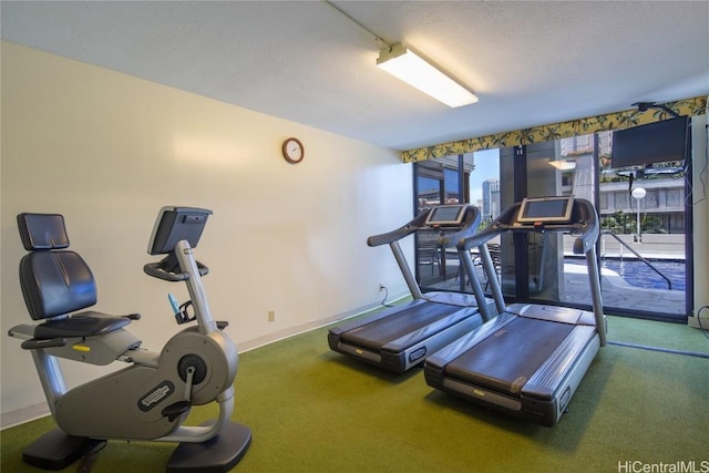 workout area featuring a textured ceiling and baseboards